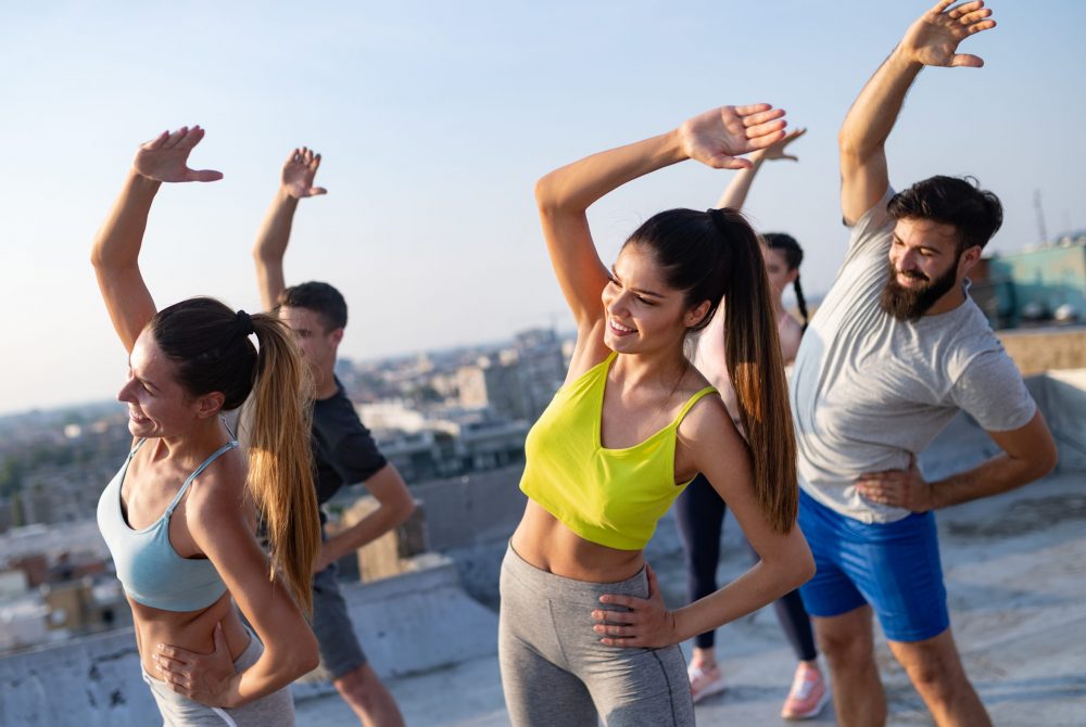 Fitness, sport, friendship and healthy lifestyle concept - group of happy friends or sportsmen exercising